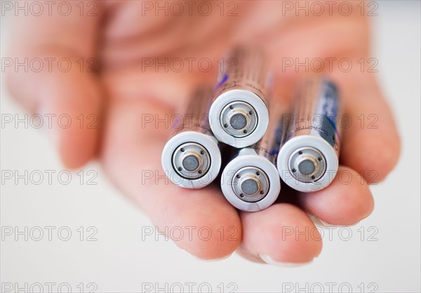 Hand holding batteries.