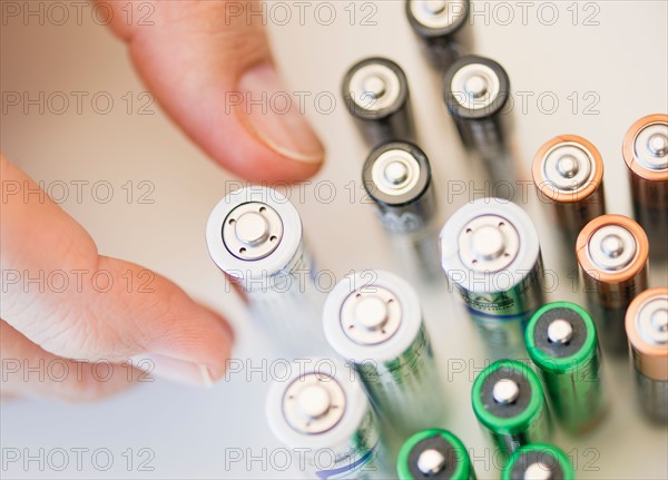 Hand holding batteries.