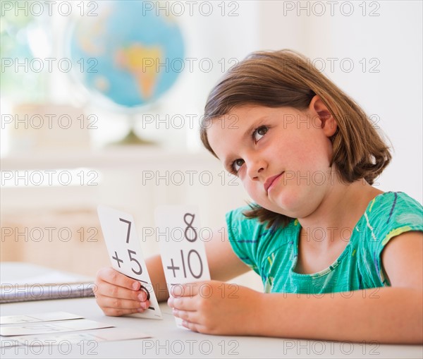 Close up of girl (6-7) counting in classroom. Photo: Daniel Grill