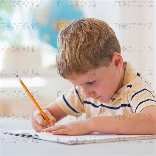 Close up of boy (4-5) writing in notebook. Photo: Daniel Grill
