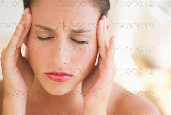 Young woman with head in hands.