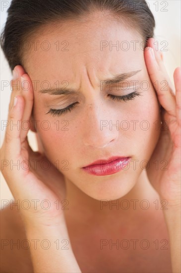 Young woman with head in hands.