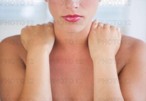 Young woman with hands on neck.