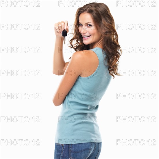 Studio portrait of beautiful woman turning around and holding car keys. Photo : momentimages