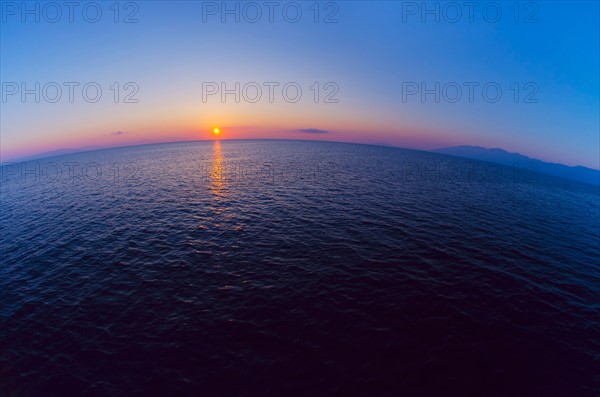 Aerial view of horizon over sea at sunrise.