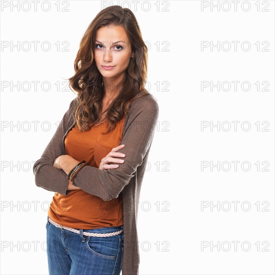 Studio shot of young woman with crossed arms. Photo : momentimages