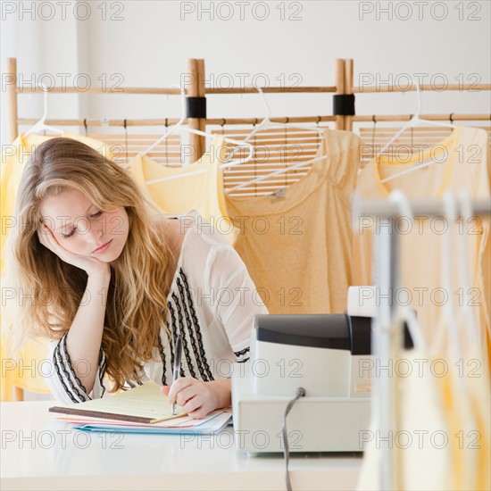 Young woman working in clothes shop. Photo : Jamie Grill