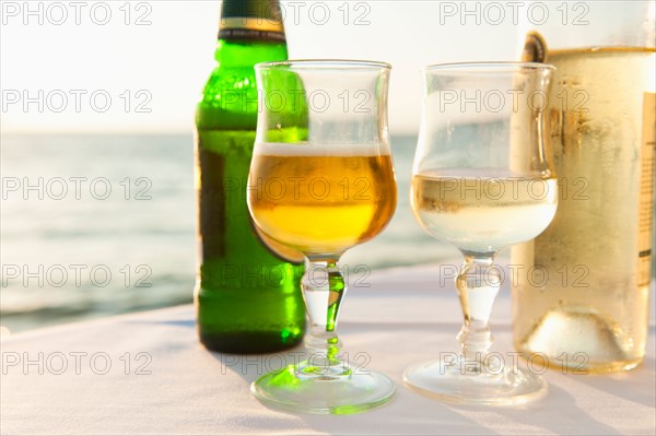 Greece, Cyclades Islands, Mykonos, Beer and wine on table by sea.