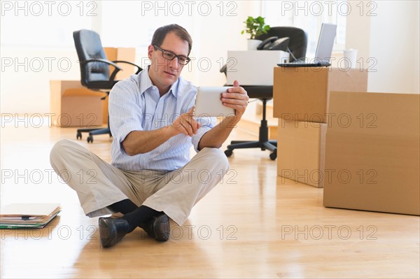 Businessman using palmtop in new office.