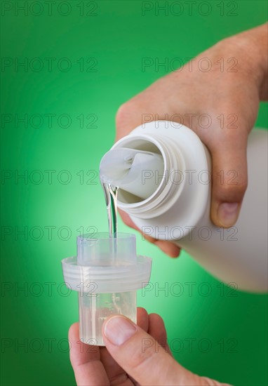 Hands pouring cleaning liquid.