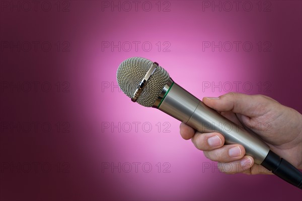Hand holding microphone.