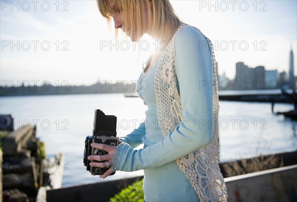 USA, Brooklyn, Williamsburg, Woman using vintage camera. Photo : Jamie Grill