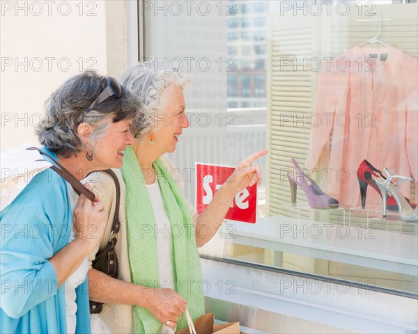 Two senior women looking at window display. Photo : Daniel Grill