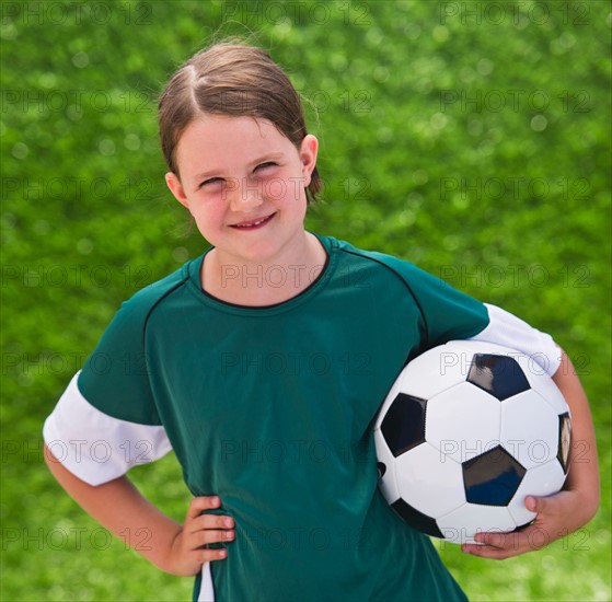 Portrait of girl (6-7) with soccer ball. Photo: Daniel Grill