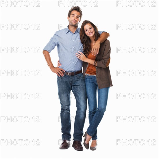 Studio shot of young couple standing together on white background. Photo: momentimages