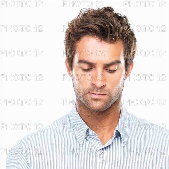 Close-up of young thoughtful business man looking down. Photo : momentimages