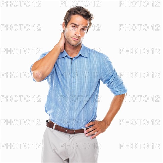 Portrait of business man standing with hand behind neck. Photo: momentimages