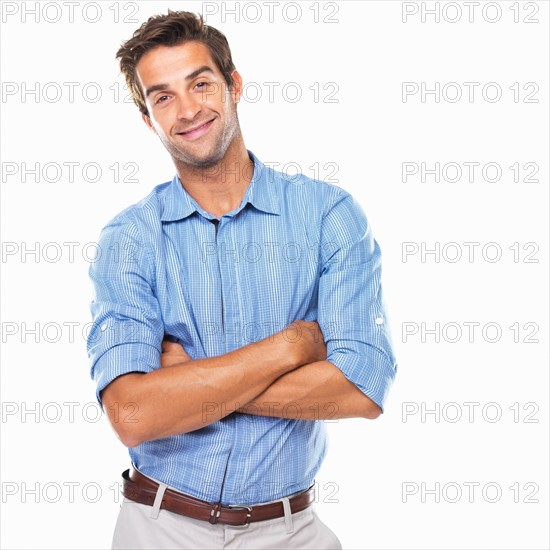 Portrait of young business man standing with hands folded and smiling. Photo: momentimages
