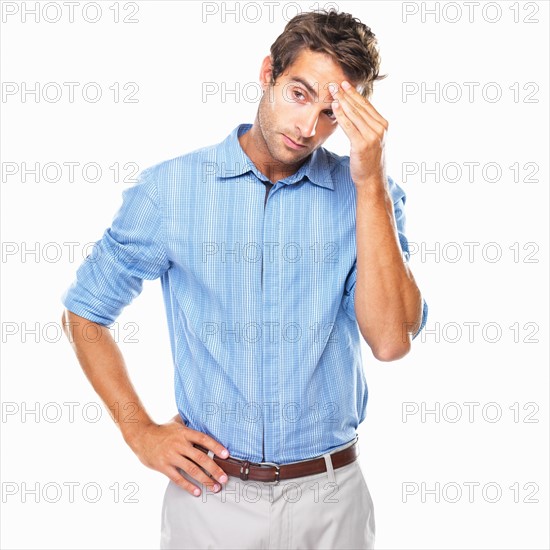 Young business man standing with hand on forehead and looking away. Photo : momentimages