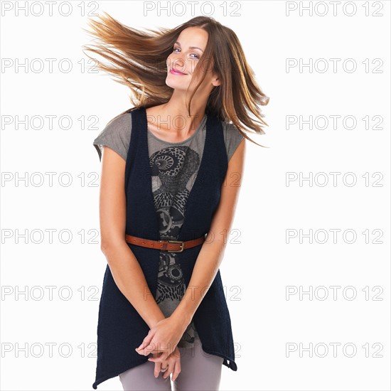 Portrait of beautiful woman standing and tossing hair. Photo: momentimages