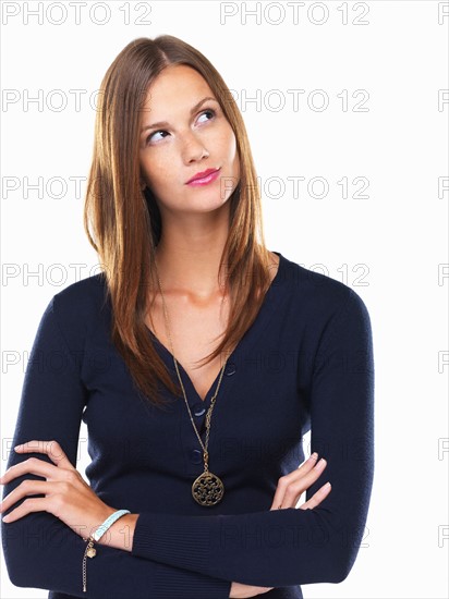 Studio portrait of thoughtful woman looking up. Photo: momentimages