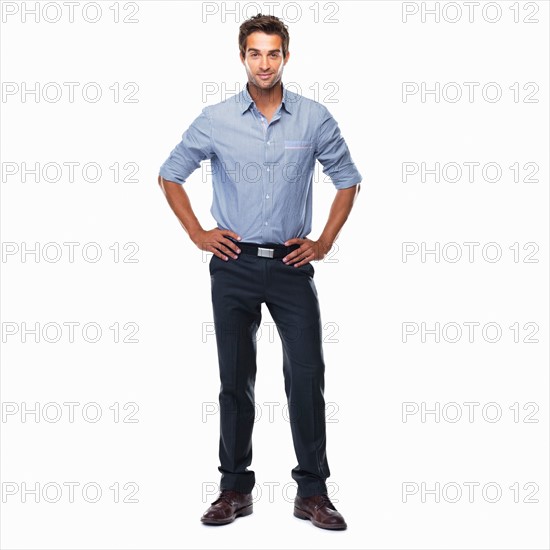 Portrait of young business man standing with hands on hips and smiling against white background. Photo : momentimages
