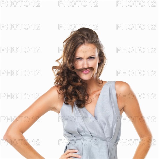 Studio portrait of playful woman with moustache made of hair. Photo: momentimages