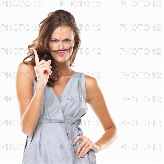 Studio portrait of playful woman with moustache made of hair . Photo : momentimages