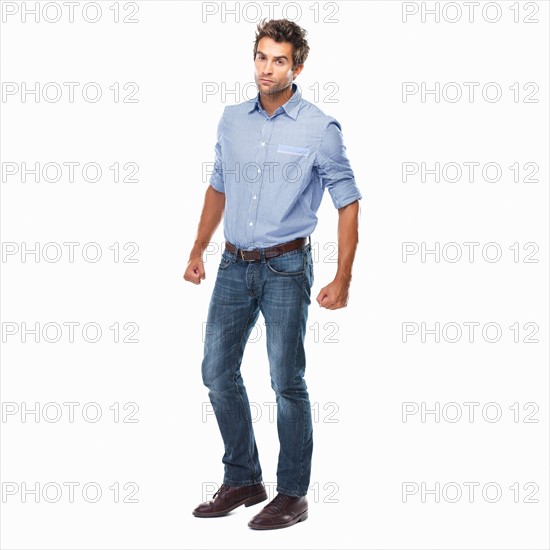 Studio shot of young man ready to fight standing on white background. Photo : momentimages