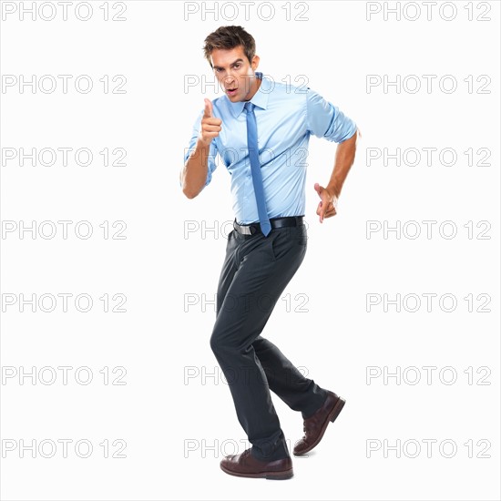 Studio shot of business man making gun shaped hands and pointing at camera. Photo : momentimages