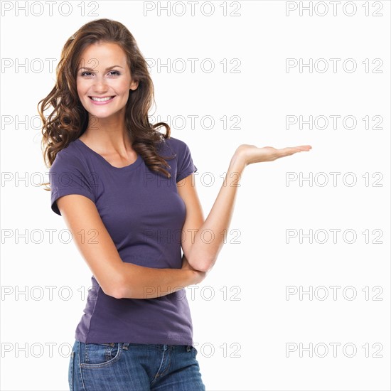 Studio portrait of attractive young woman gesturing and smiling. Photo: momentimages