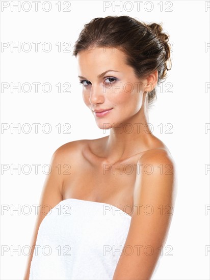 Studio portrait of beautiful woman wrapped in towel. Photo: momentimages