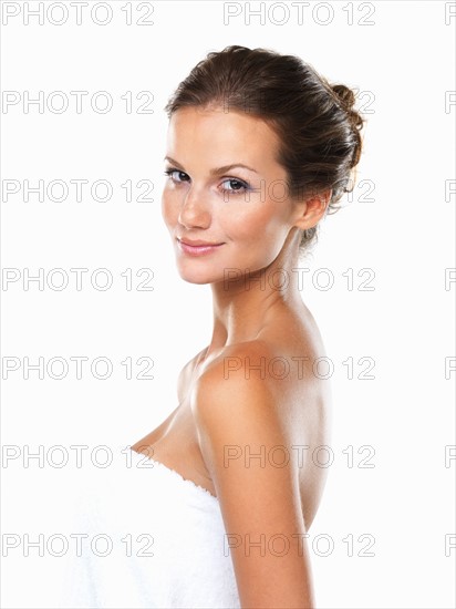 Studio portrait of beautiful woman wrapped in towel. Photo: momentimages
