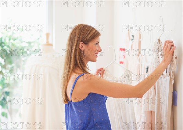 Young woman in clothes shop. Photo : Daniel Grill