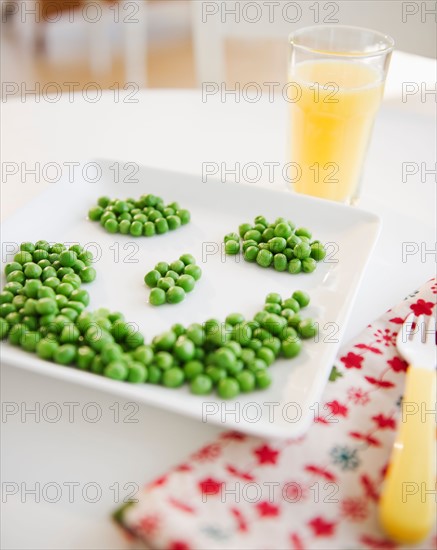 Close up of smiley on plate made of green peas. Photo : Jamie Grill