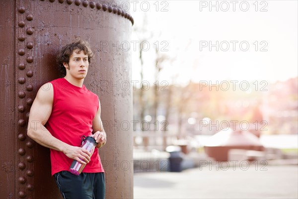 USA, Washington State, Seattle, Young athlete leaning against building. Photo : Take A Pix Media