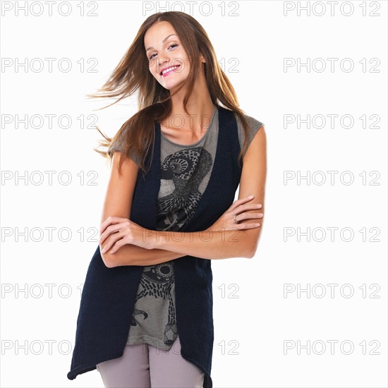 Portrait of cute young woman standing with arms crossed. Photo : momentimages