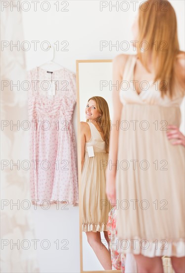 Young woman in clothes shop fitting dress. Photo : Daniel Grill