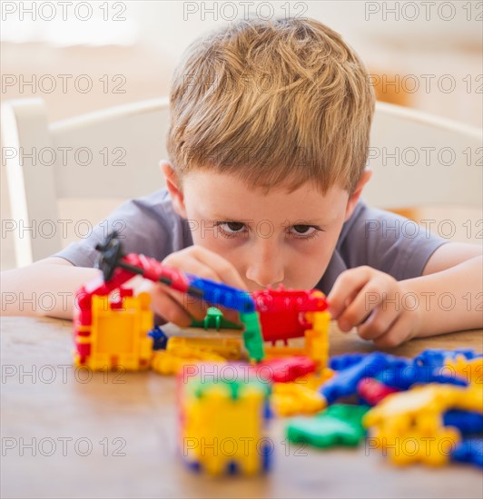 Close up of boy (4-5) playing with plastic blocks. Photo: Daniel Grill