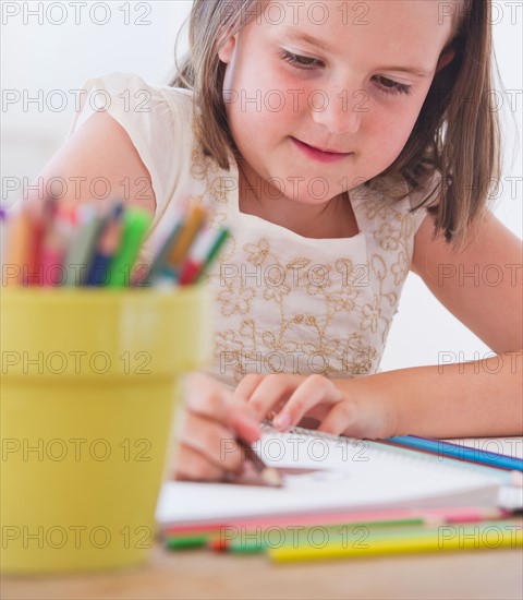 Close up of girl (6-7) drawing in notebook. Photo : Daniel Grill