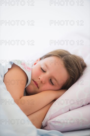Close up of girl (6-7) sleeping in bed. Photo: Daniel Grill