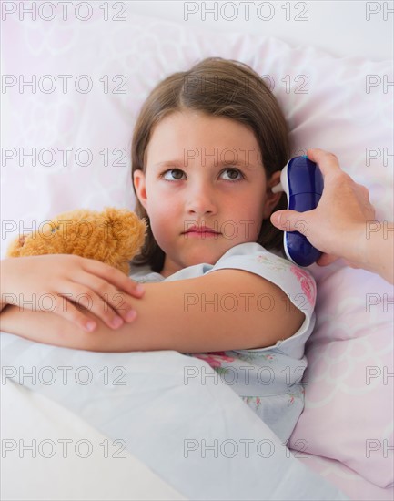 Close up of sick girl (6-7) lying in bed. Photo : Daniel Grill