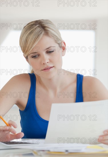 Young blond woman doing paperwork. Photo : Jamie Grill