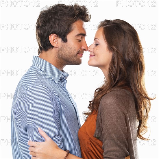 Studio shot of young couple rubbing noses. Photo: momentimages