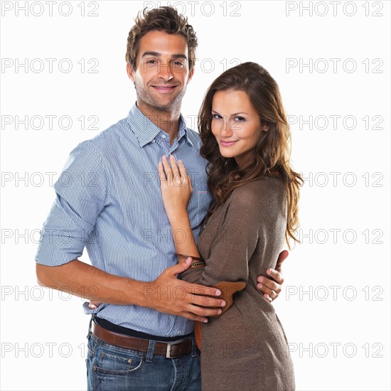 Studio shot of young attractive couple smiling. Photo: momentimages