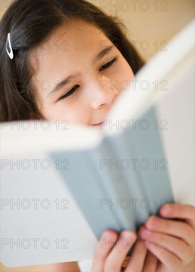 Portrait of girl (10-11) reading book. Photo: Jamie Grill