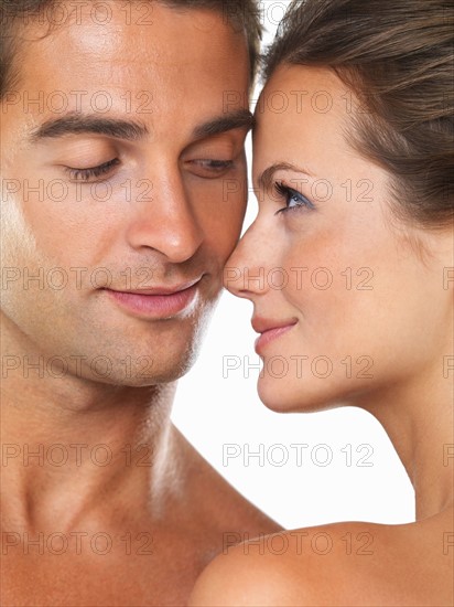 Studio portrait of young attractive couple looking at each other. Photo: momentimages