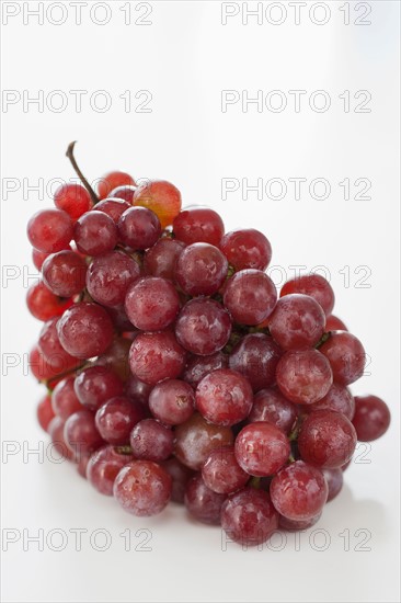 Fresh red grapes on white background.