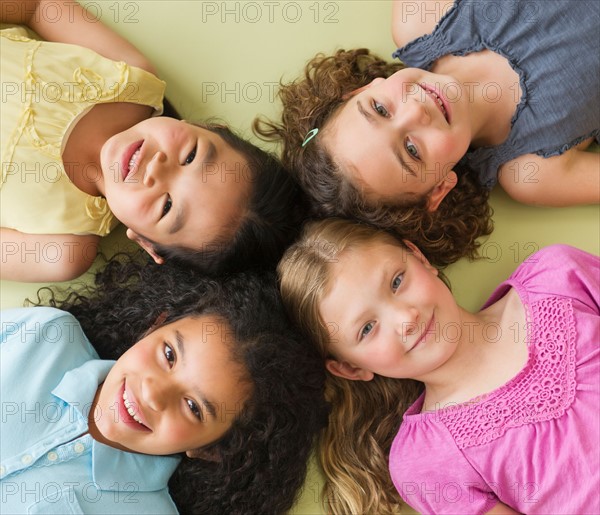 Portrait of girls (6-9) lying on floor.