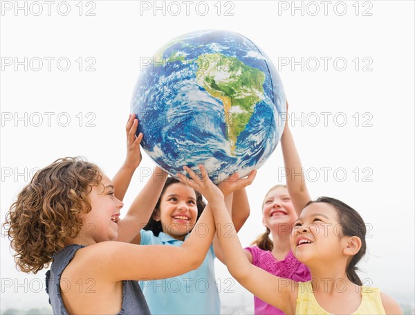 Girls (6-9) holding globe.